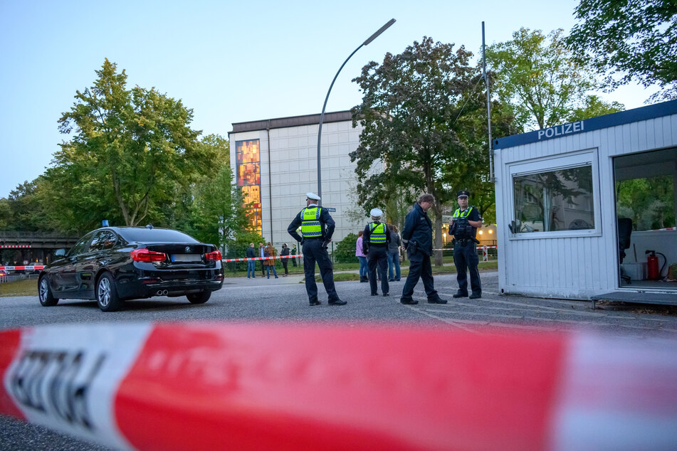 Mehrere Polizeibeamte und Zivilisten stehen nach dem Angriff vor der Synagoge.