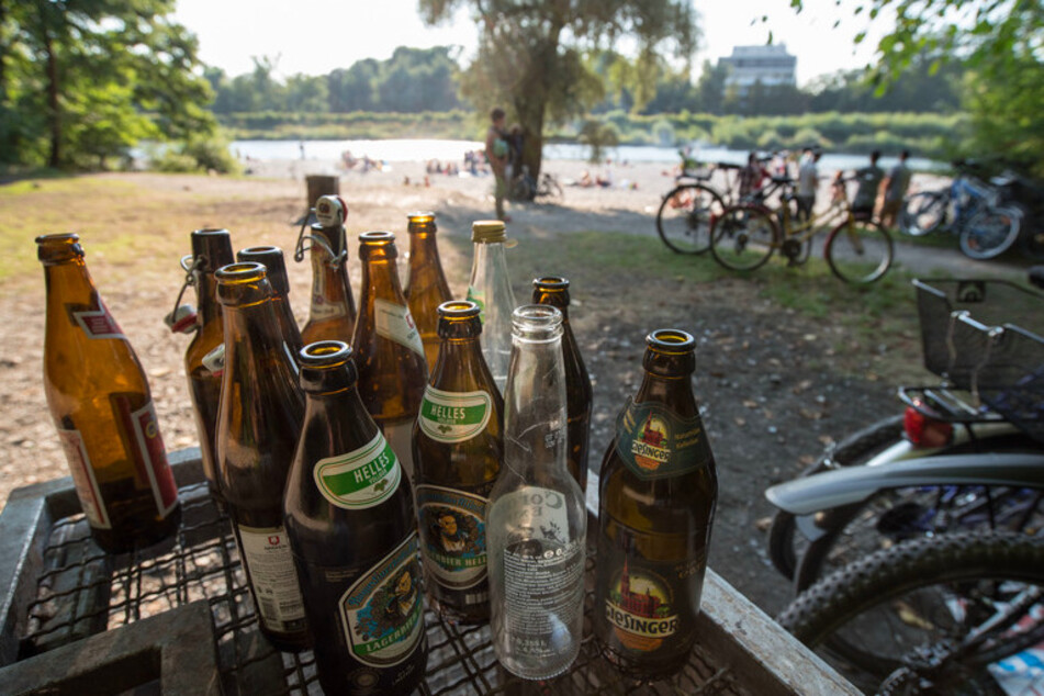 Leere Bierflaschen stehen am Flaucher an der Isar auf einem Abfallcontainer.