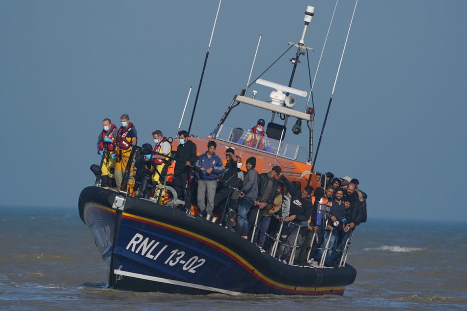 Eine Gruppe vermutlicher Migranten wird nach einem Zwischenfall mit einem kleinen Boot im Ärmelkanal mit einem Rettungsboot an Land gebracht.