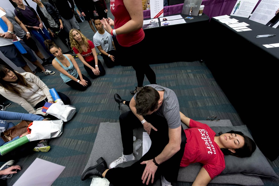 Two OM instructors demonstrating an orgasmic meditation exercise at an LA convention.