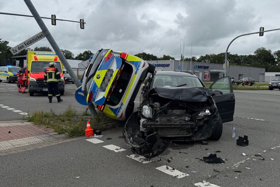 Das Polizeiauto steckte senkrecht zwischen dem VW und einer Laterne fest.
