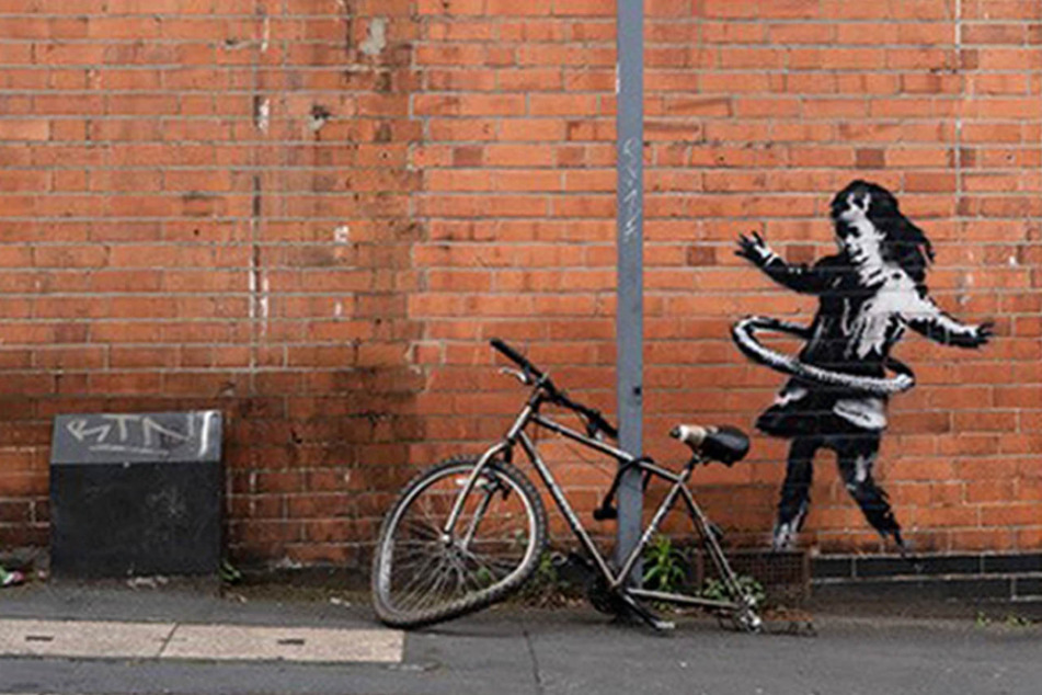 Das neueste Street-Art-Werk des britischen Künstlers Banksy auf einer Backsteinfassade in der Rothesay Avenue zeigt ein Mädchen, das mit einem Hula Hoop Reifen spielt.