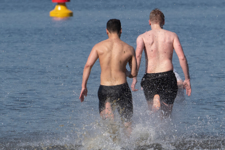 Zwei Männer stürzen sich beim Start der Badesaison am Strandbad Wannsee ins Wasser. (Archivbild)