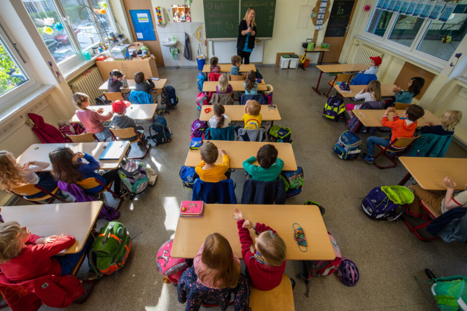 Schüler einer ersten Grundschulklasse sitzen im Unterricht auf ihren Plätzen.