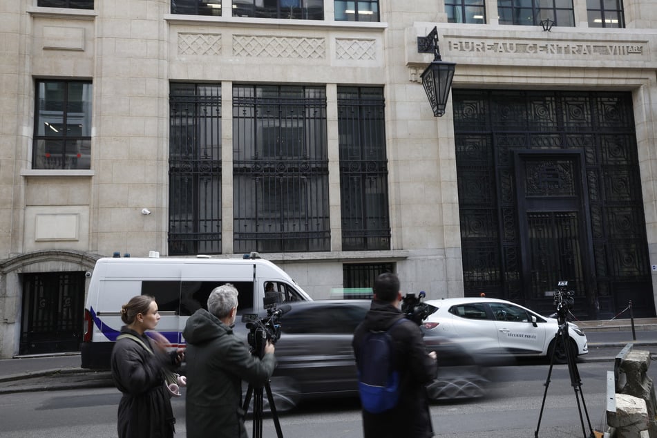 Media representatives gather outside the Bank of America building in the 8th arrondissement of Paris on March 28, 2026.