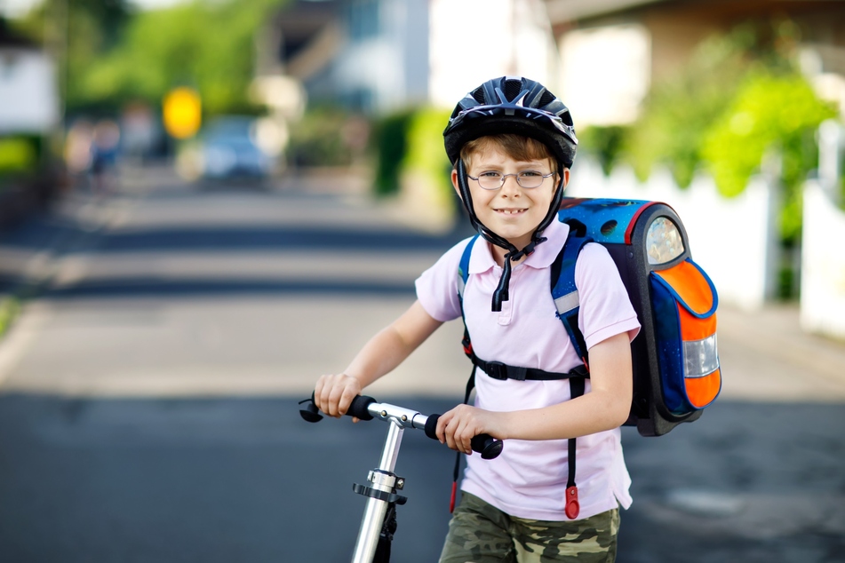 Zu einer kindgerechten Schutzausrüstung für Kinder im Straßenverkehr gehört unter anderem ein Fahrradhelm sowie Reflektoren an Rucksack und Kleidung.