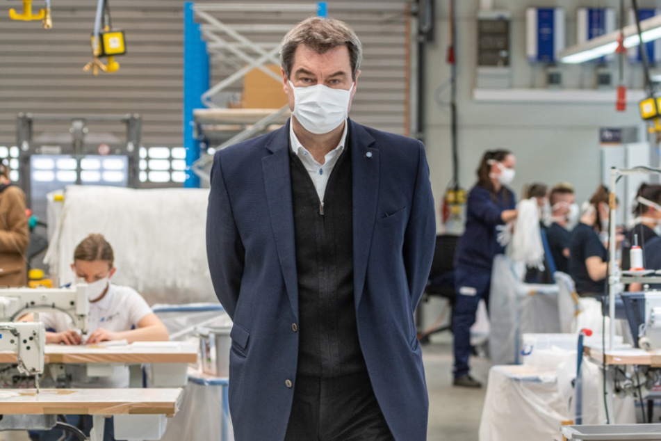 Markus Söder (CSU), Ministerpräsident von Bayern, steht in einer Produktionshalle des Automobilzulieferers Zettl, der nun Masken herstellt.