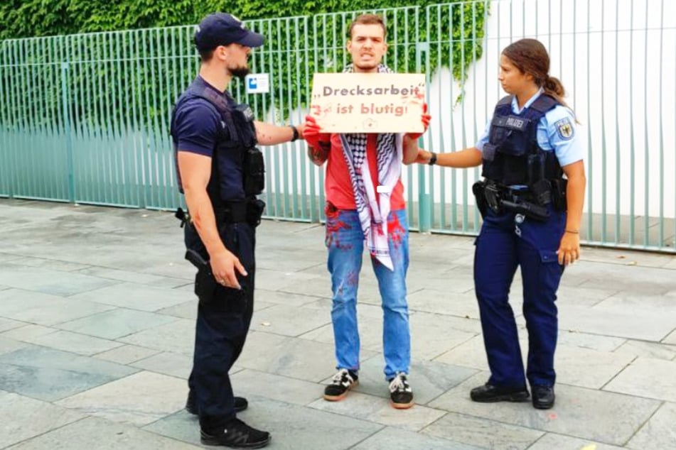 Fabian Reese (26, M.) von der Neuen Generation posiert für ein Foto mit den Ordnungskräften.