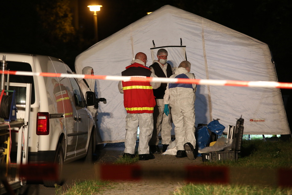 Polizisten stehen vor einem Zelt, das für die Ermittlungen aufgestellt wurde.
