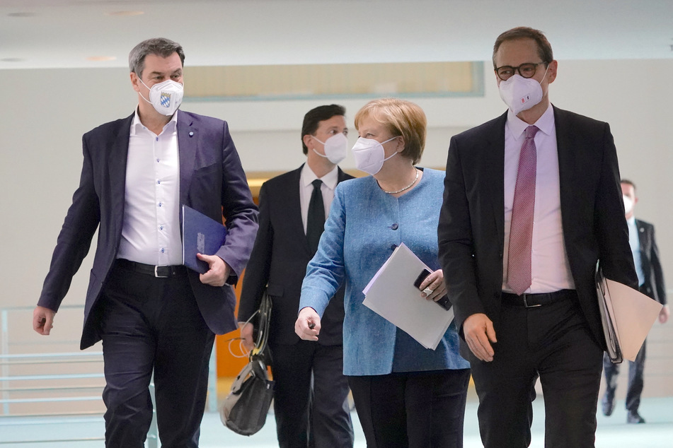 Bundeskanzlerin Angela Merkel (66, CDU) kommt neben Markus Söder (54, CSU, l.), Ministerpräsident von Bayern und CSU-Vorsitzender, und Michael Müller (56, SPD, r.), Regierender Bürgermeister von Berlin, zu der Pressekonferenz nach dem Impfgipfel im Kanzleramt.