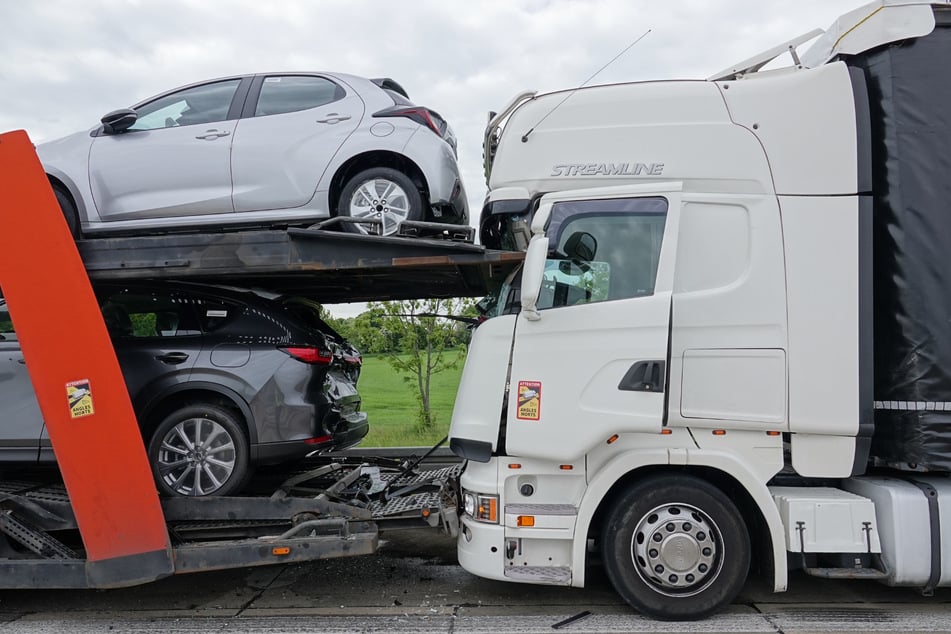 Ein Lkw am Unfallort klemmt im Auflieger eines Autotransporters.