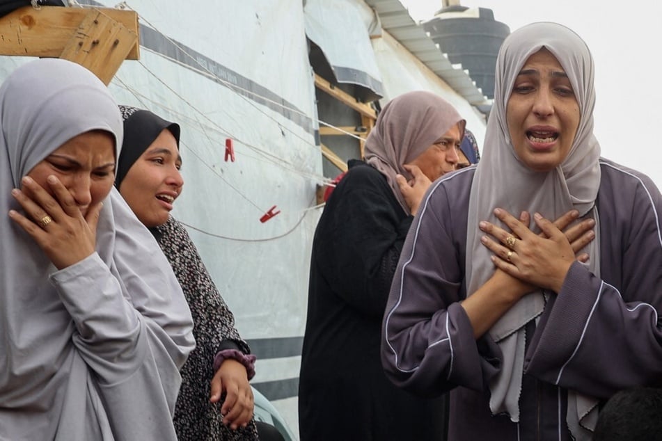 Palestinian women mourn following the Israeli strike on a Rafah refugee camp.