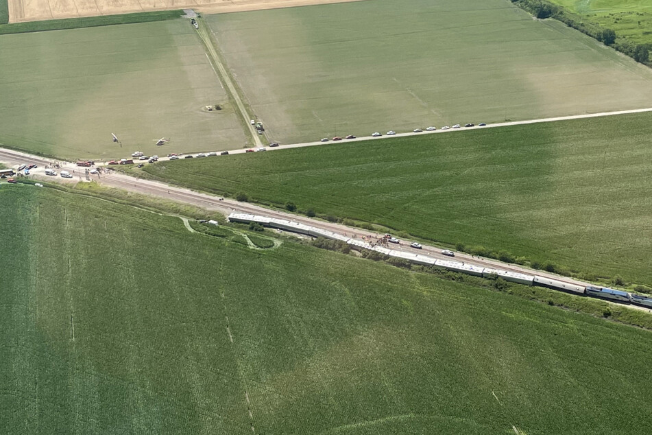 An aerial view of the wreckage shows numerous derailed train cars after the crash.