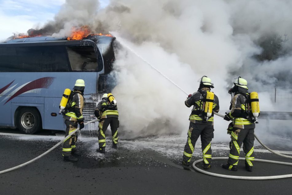 Die Feuerwehr bei den Löscharbeiten. Der Reisebus brannte vollständig aus.