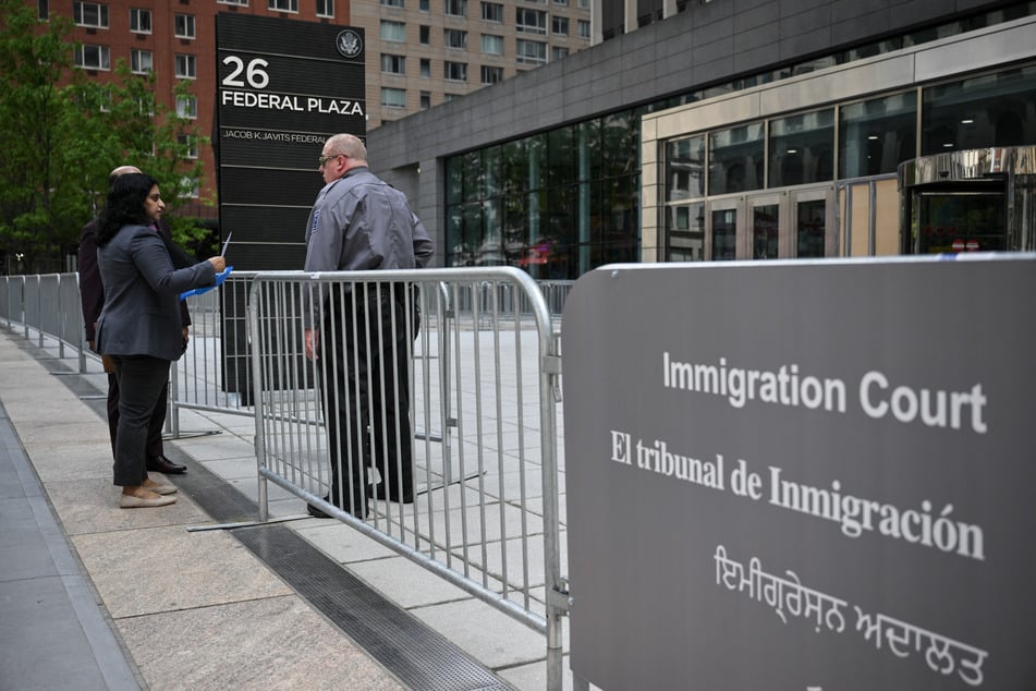 A security guard speaks to people at the entrance to the US Immigration and Customs Enforcement building at 26 Federal Plaza on May 8, 2025, in New York City.