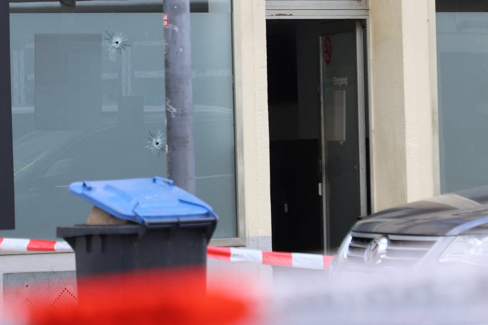 In der Fassade des Ladenlokals sind mehrere Einschusslöcher zu sehen.