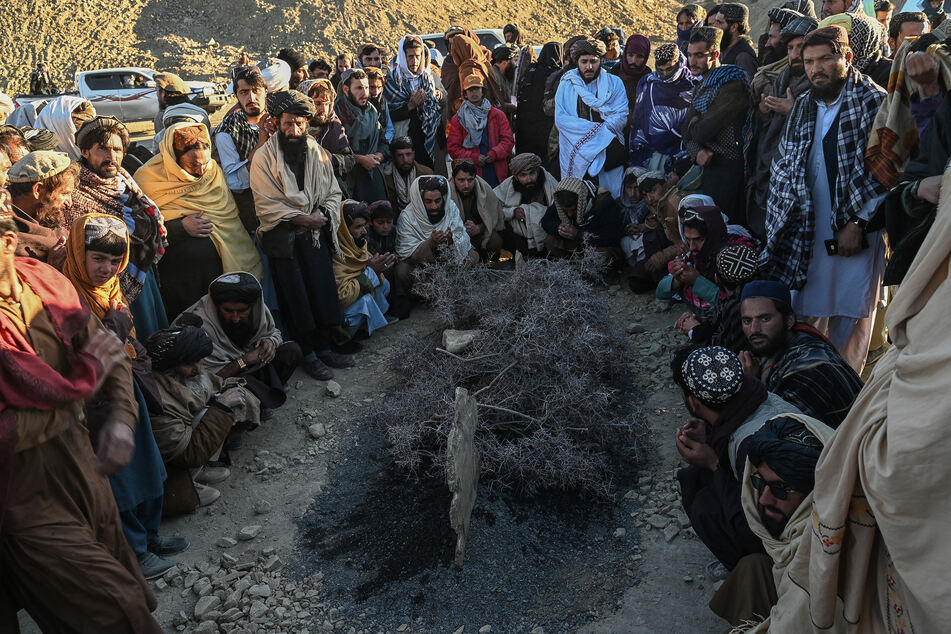 Afghan men offer prayers as they gather around the grave of Khalil Ur-Rahman Haqqani, the Minister for Refugees and Repatriation, during the funeral ceremony in Sarana of Paktia province, south of Kabul, on December 12, 2024.