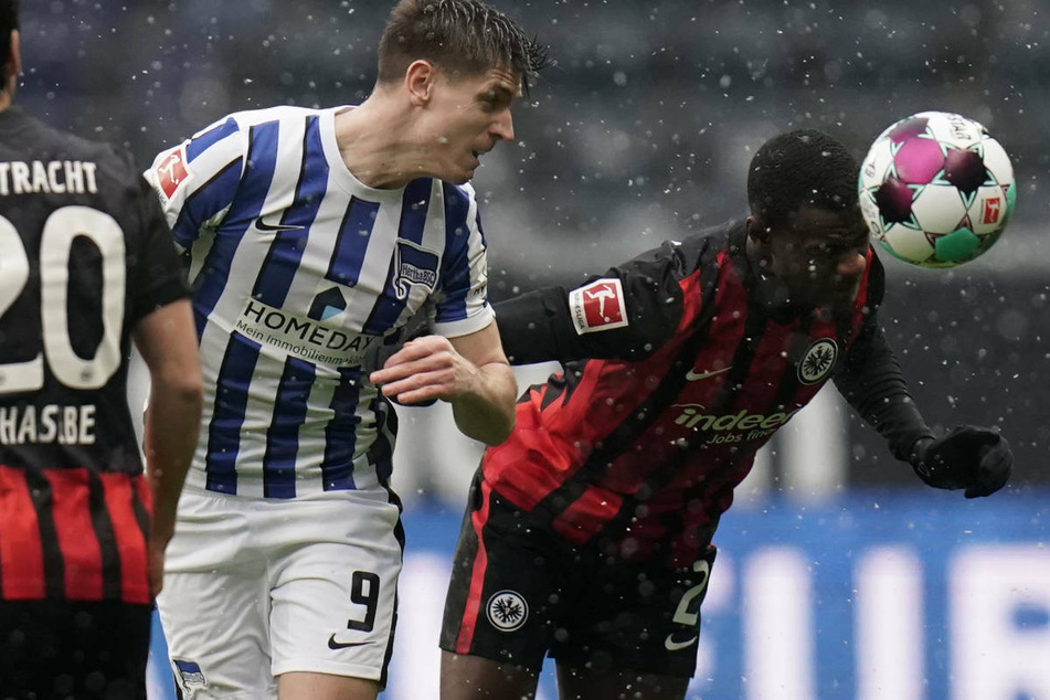 Harter Zweikampf im Schneeregen: Herthas Krzysztof Piatek (M.) gegen den Frankfurter Evan N'Dicka.