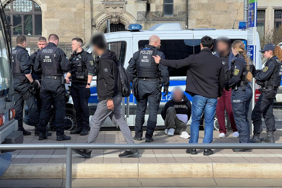 Eine Person sitzt mit auf dem Rücken gefesselten Händen am Boden.