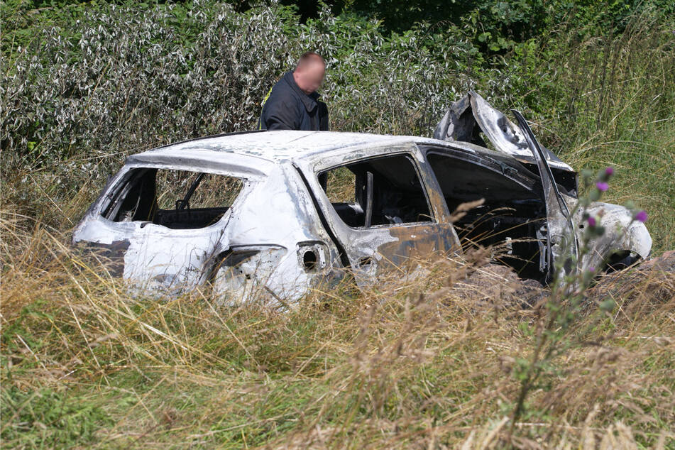 In dem verkohlten Auto fanden Feuerwehrleute eine Leiche.