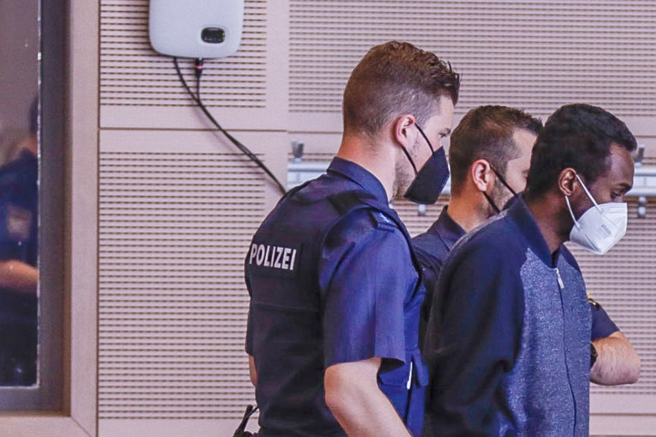 Der Angeklagte wird am ersten Prozesstag an seinen Platz geführt. Der Prozess gegen den Messerstecher von Würzburg findet in einer Veranstaltungshalle im unterfränkischen Veitshöchheim statt.