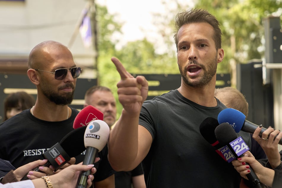 Andrew Tate (l.) und sein Bruder Tristan Tate während einer Rede vor einer rumänischen Polizeistation.
