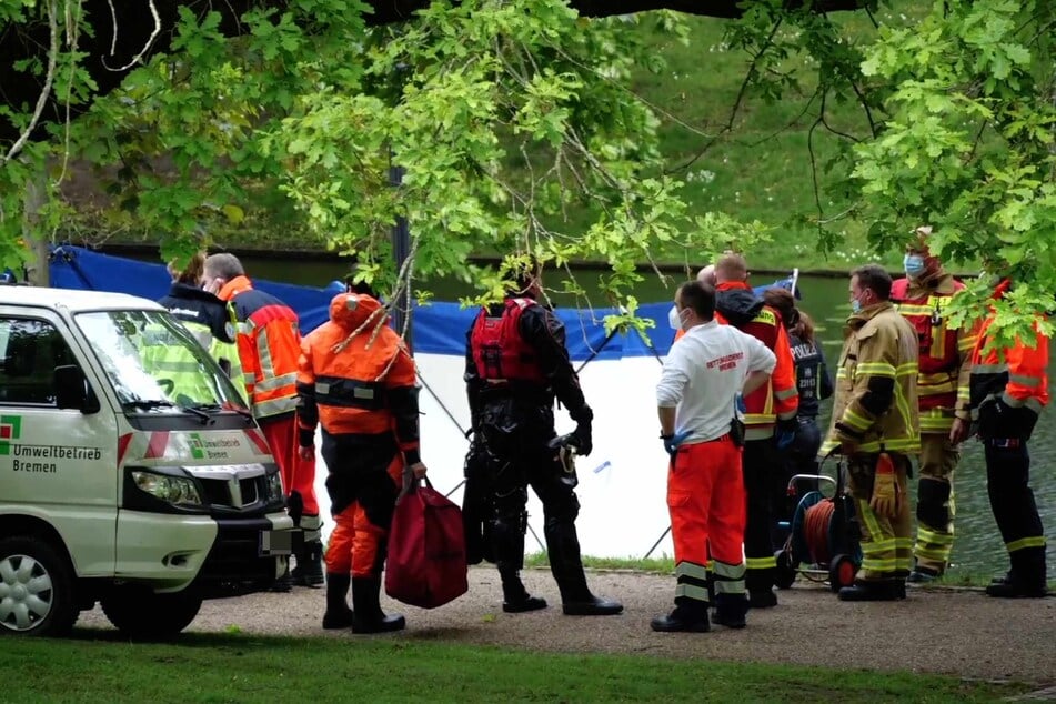 Zahlreiche Einsatz- und Rettungskräfte stehen rund um den Fundort der Leiche.
