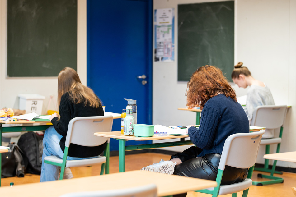 Schülerinnen und Schüler sitzen während der schriftlichen Prüfung in Biologie in einem Klassenzimmer eines Gymnasiums.