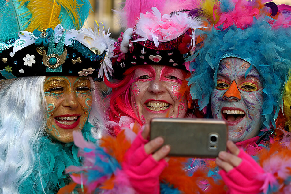 Das Handy immer mit dabei: Feiernde Jecken machen in Köln ein Selfie.