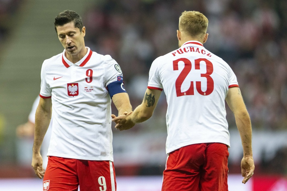 Tymoteusz Puchacz (r.) klatscht im WM-Spiel gegen England mit Teamkollege Lewandowski ab.