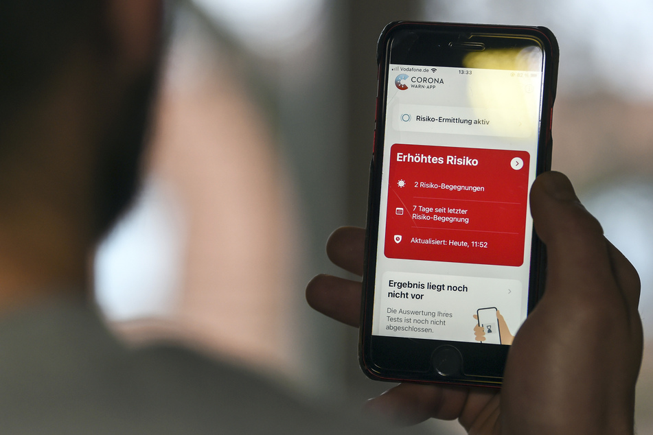 Auf einem Handy zeigt die Corona Warn-App ein erhöhtes Risiko an.