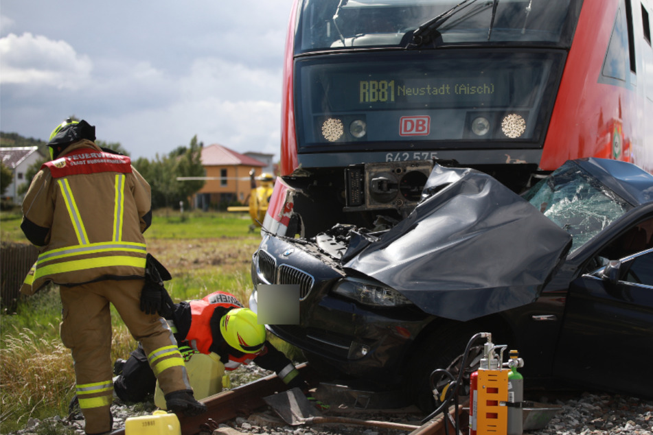BMW kracht in Zug und wird mitgeschleift: Fahrer überlebt schwer verletzt
