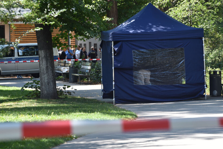Beamte der Spurensicherung sichern in einem Faltpavillon Spuren an einem Tatort im kleinen Tiergarten.