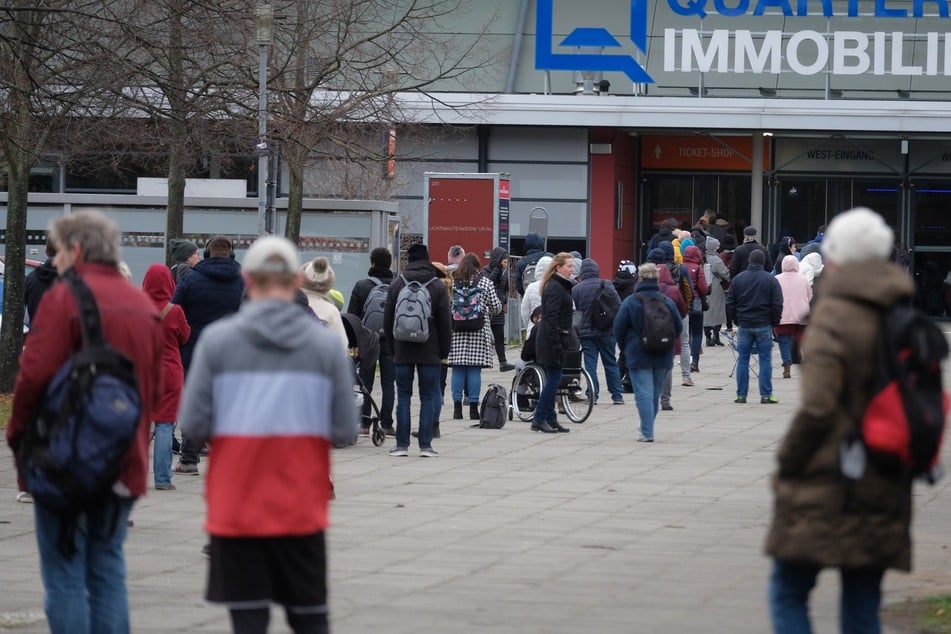 Menschen stehen vor der Quarterback-Immobilien-Arena, um sich impfen zu lassen. Leipzig bildet weiterhin die Region in Sachsen mit dem niedrigsten Inzidenzwert.