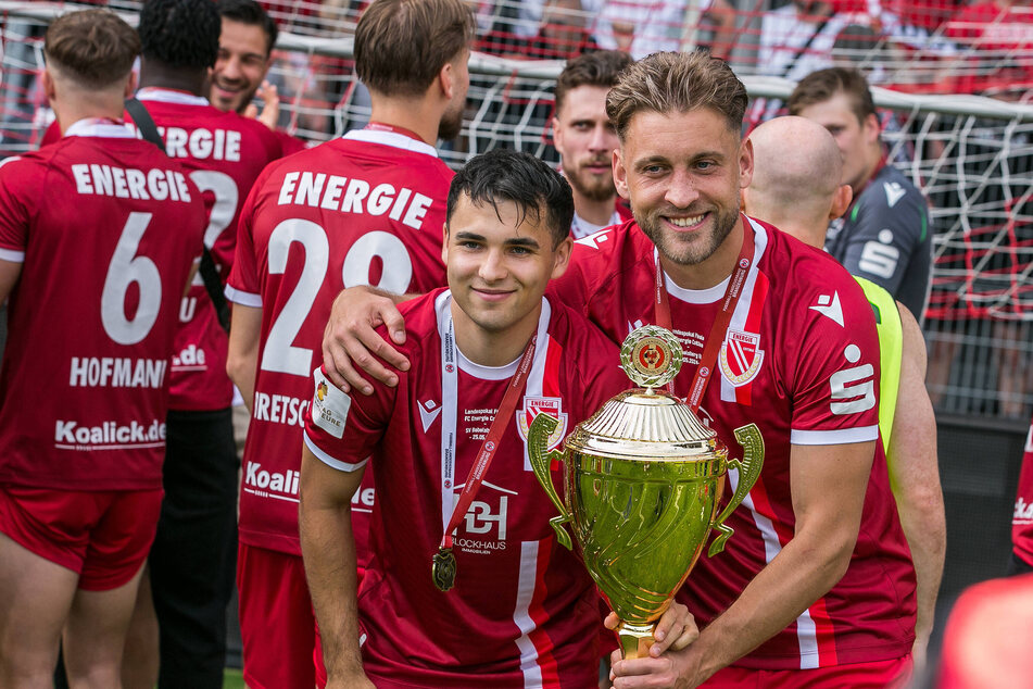 Jan Shcherbakovski (23, v.l.) zusammen mit Dennis Slamar (29, v.r.) und dem Regionalliga-Pokal. Die Dynamo-Leihgabe stieg mit Cottbus in die 3. Liga auf - und soll nun bleiben.