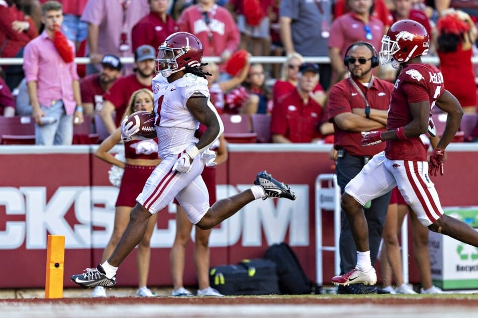 Jahmyr Gibbs (l) of the Alabama Crimson Tide scores a touchdown in the second half during a game against the Arkansas Razorbacks at Donald W. Reynolds Razorback Stadium.