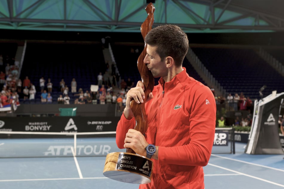 Nach seinem Finalsieg gegen Sebastian Korda (22) verpasst Novak Djokovic der Siegestrophäe einen dicken Schmatzer.