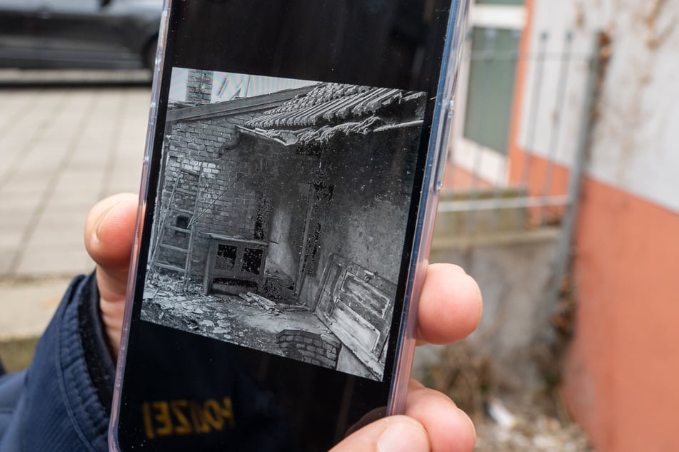 Ein Polizeibeamter hält ein Handy mit dem Foto aus dem Jahre 1978 von dem Fundort der 15-jährigen Christa Mirthes: einem Brunnenschacht in Schwandorf.