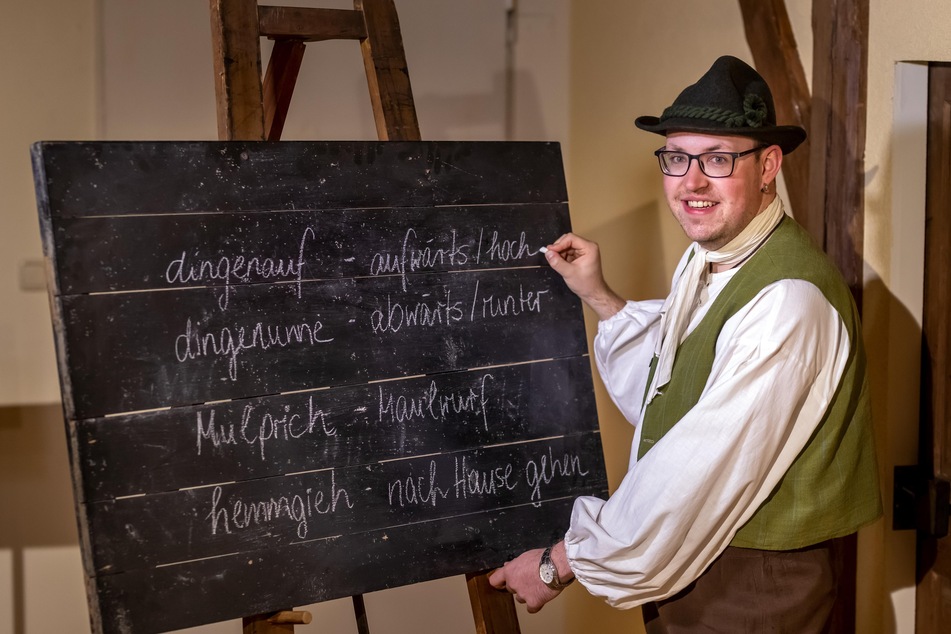 Robby Schubert (26) vom Ersten Deutschen Strumpfmuseum schreibt typische "Gälner Wörter" und ihre Übersetzung an eine Tafel.