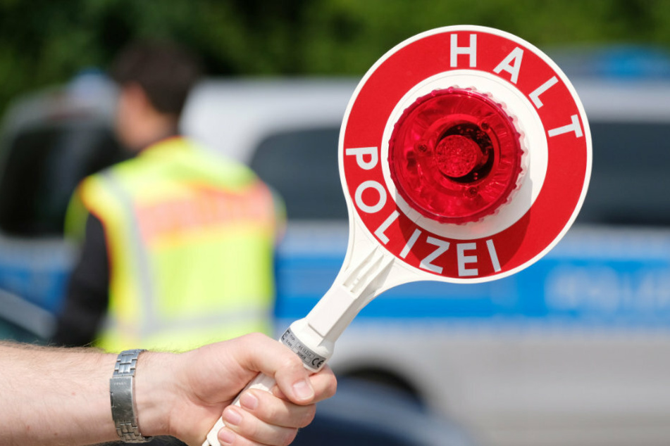 Ein Polizist kontrolliert auf den Straßen in Sachsen die Fahrzeuge. (Symbolbild)