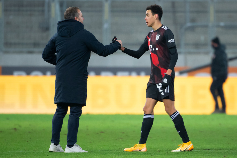 Trainer Hansi Flick (55, l.) von München und Jamal Musiala (17) von München stehen nach dem Spiel zusammen.