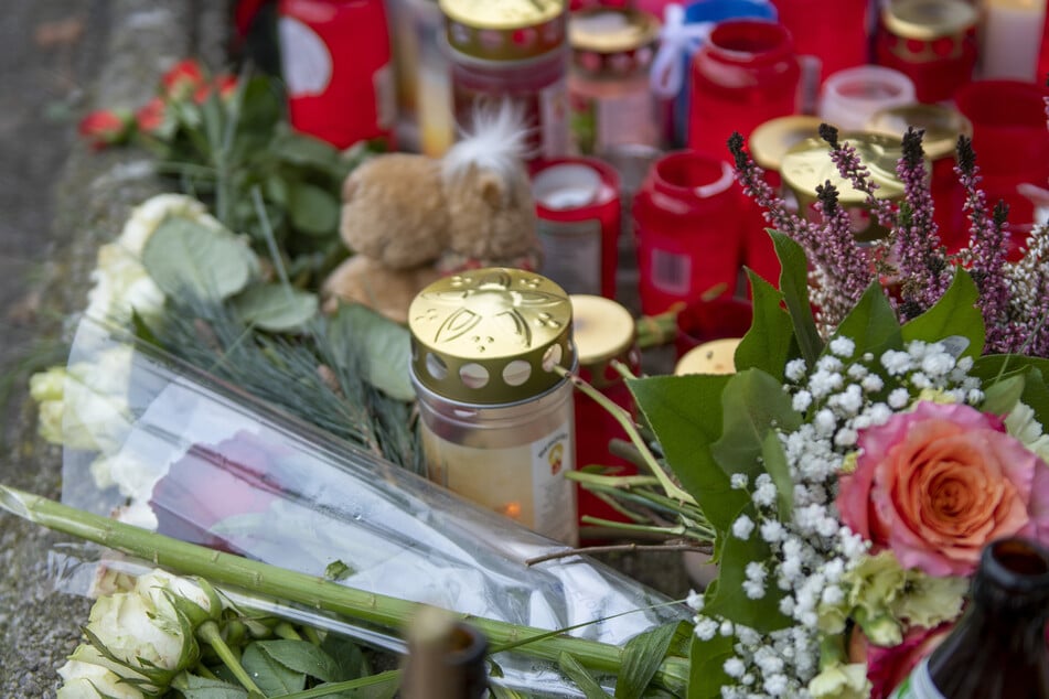 Blumen und Kerzen lagen an der Bushaltestelle in Augsburg, an der ein Mann durch Stiche getötet wurde. (Archivbild)