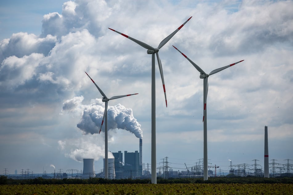 Windräder drehen sich vor der Kulisse des Braunkohlekraftwerks Schkopau westlich von Halle (Saale). (Archivbild)