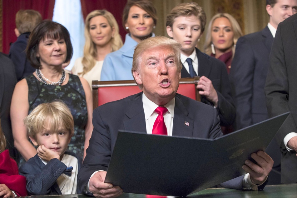 Donald Trump surrounded by members of his family as he formally signs his cabinet nominations into law in Washington, DC on January 20, 2017.