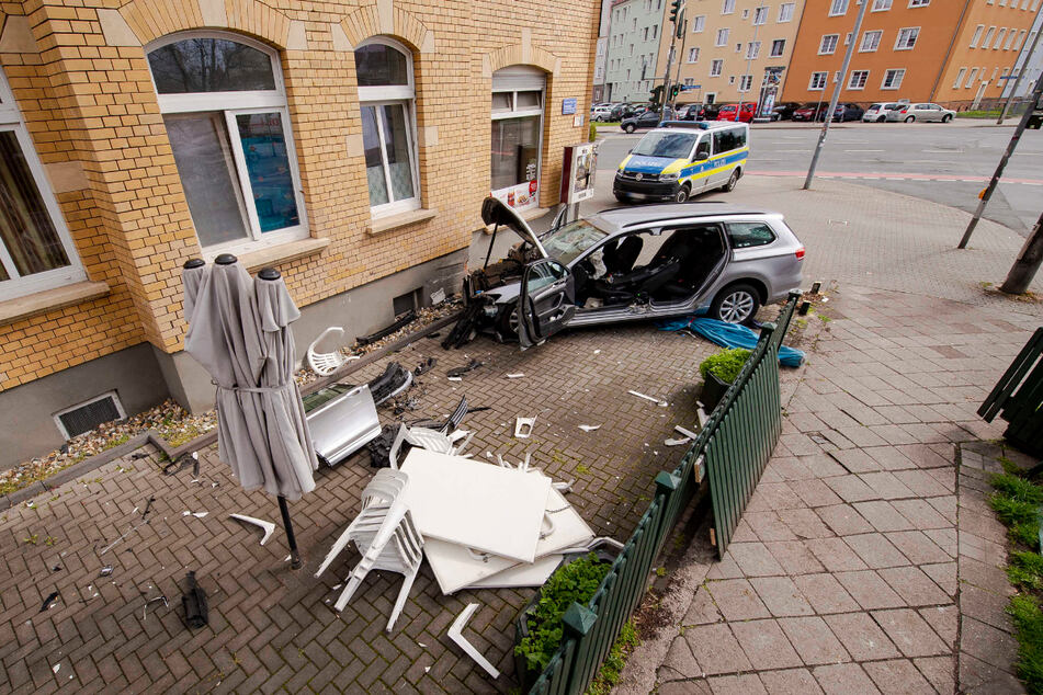 Der VW-Passat steht vollkommen zerstört vor einer Hauswand.
