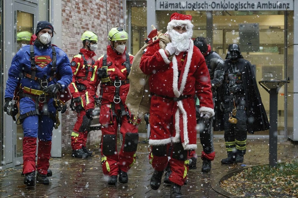 Die als Superhelden und Nikolaus verkleideten Mitglieder der Feuerwehr-Höhenretter besuchen die Kinder im UKE.