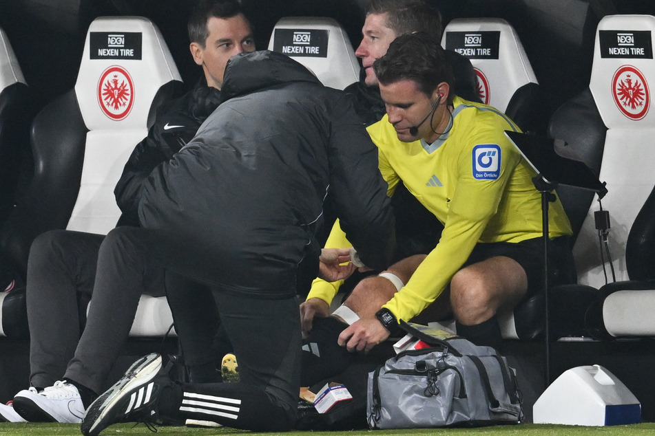 Felix Brych (48) wurde von DFB-Physiotherapeuten und den Ärzten von Eintracht Frankfurt behandelt, pfiff zunächst weiter. In der Halbzeit kam das Aus für den Schiri.