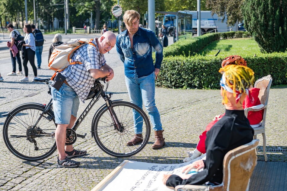 Ein Radfahrer hält an und bestaunt die ungewöhnliche Kunstaktion.