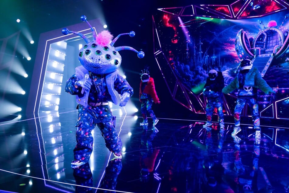 Alien "Cosma" sang "Freed from Desire" und versuchte dabei seine Stimme zu verstellen.