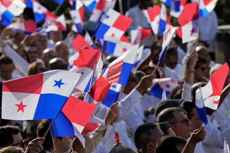 Attendees wave Panamanian flags during the ceremony to mark the 25th anniversary of the US' handover of the interoceanic Panama Canal to Panama, in Panama City on Tuesday.